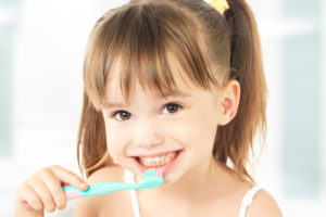 happy little girl brushing her x